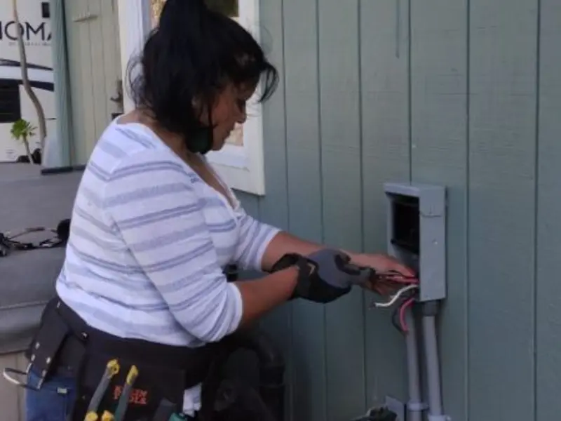 Licensed electrician wiring an exterior subpanel in Northfield